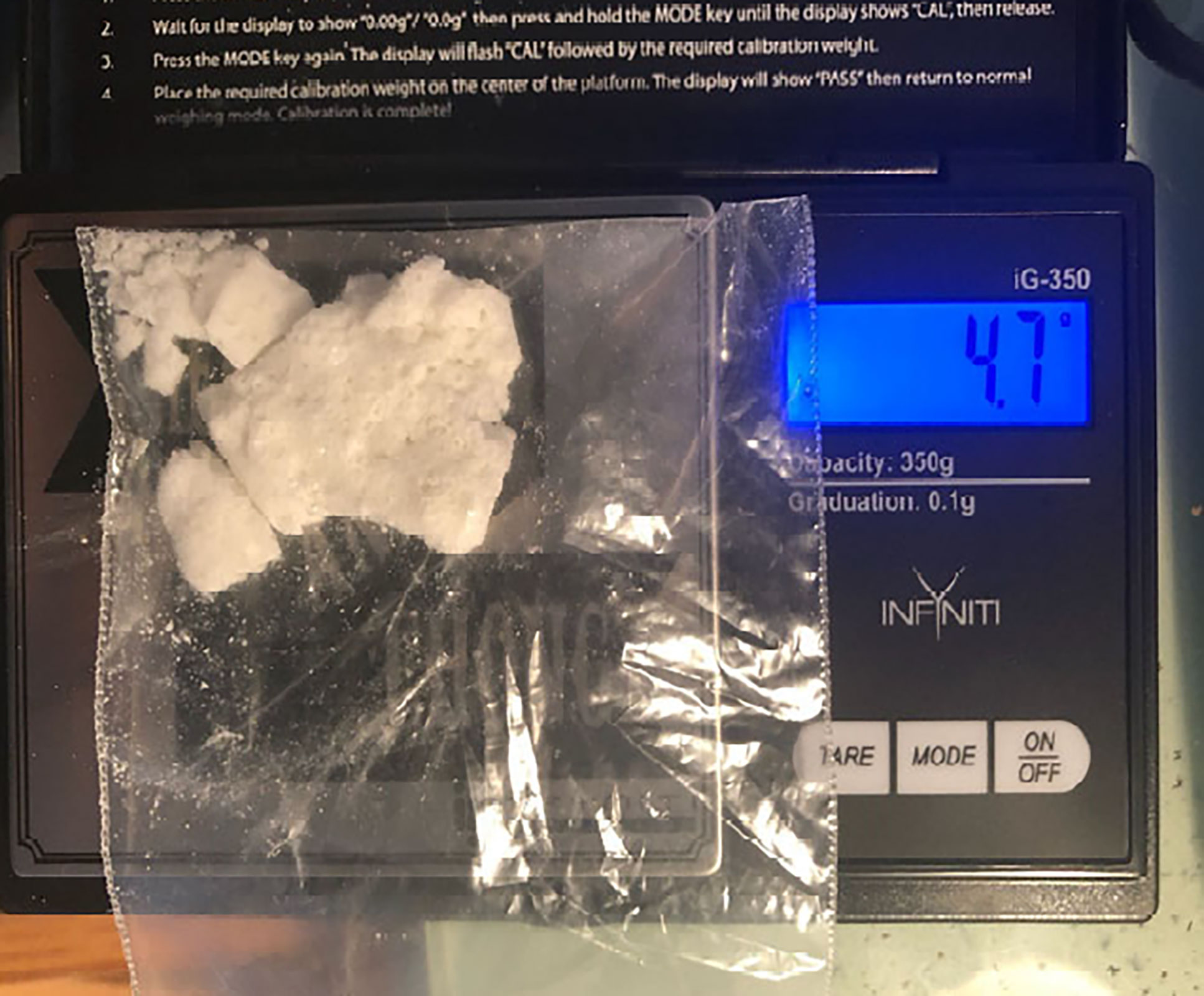 This photo from the US Department of Justice shows a white substance that appears to be cocaine on a scale.